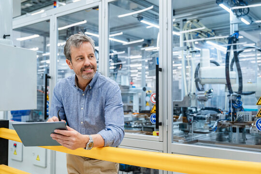 Engineer with tablet supervising automation at factory
