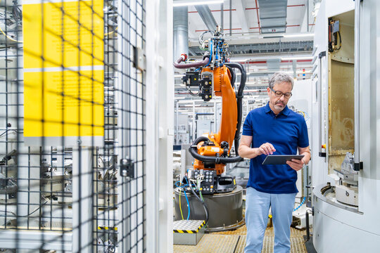 Engineer using tablet for automation control in modern factory