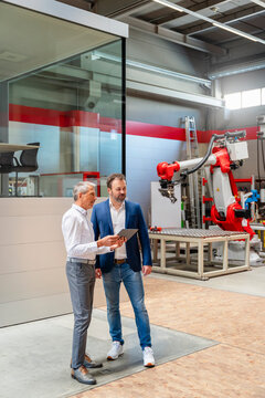 Manager and engineer planning with tablet in automation factory
