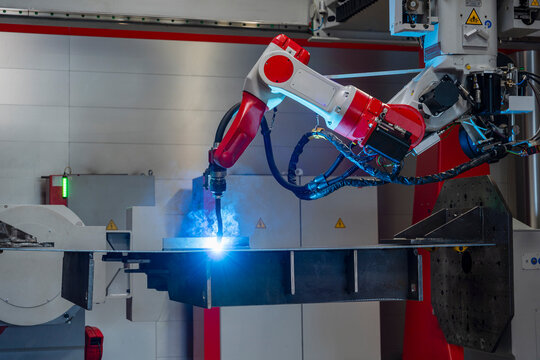 Automated industrial robot arm welding metal in a factory