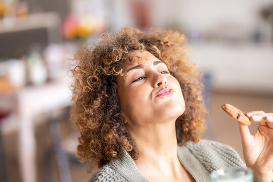 Smiling mid adult woman eating a cookie