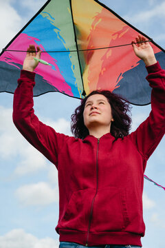 Enjoying a windy spring day holding a colorful kite in the park