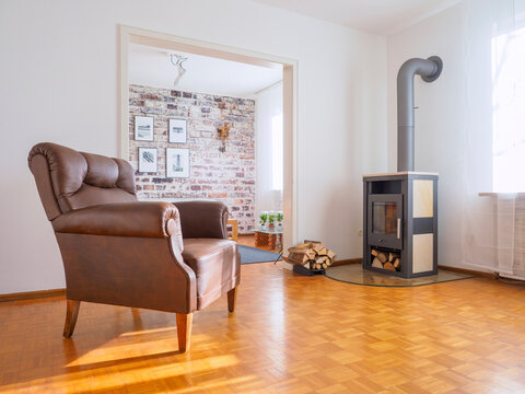 Germany, modern living room, leather chair and fireplace