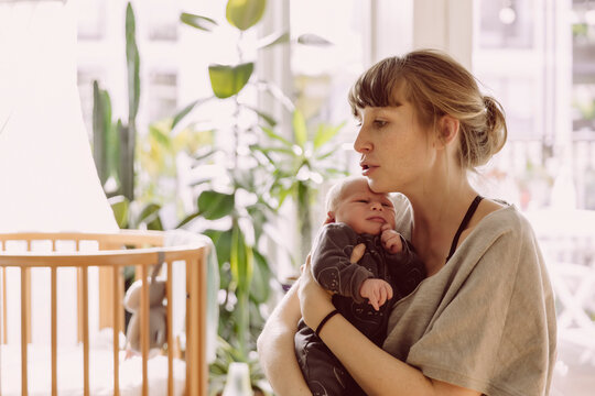 Mother soothing and comforting her newborn baby boy at home