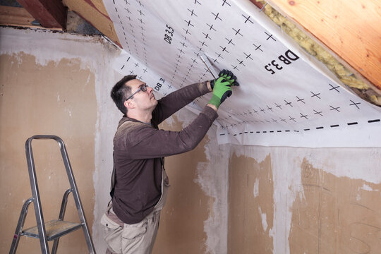 Roof insulation, worker fixing sarking membrane