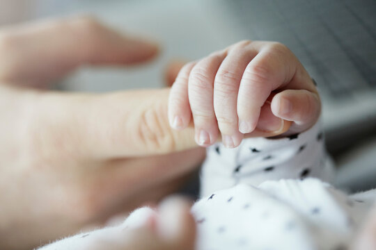Close-up of baby holding father's finger