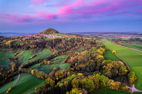 Germany, Baden-Wurttemberg, Drone view of autumn grove at moody dusk with Hohenstaufen mountain in distant background
