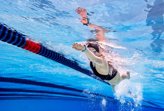 Athlete swimming freestyle underwater in a pool
