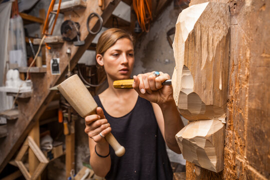 Sculptress carving wooden figure