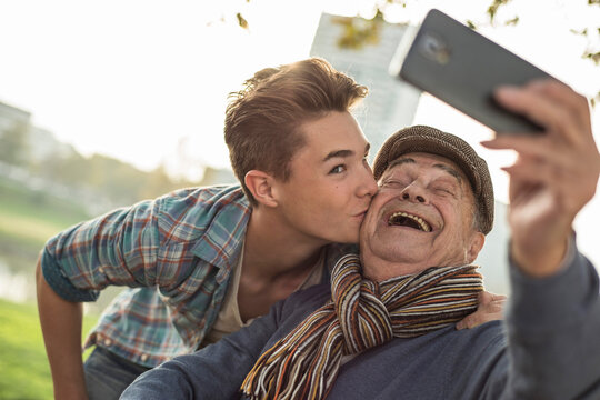 Happy senior man taking a selfie with grandson