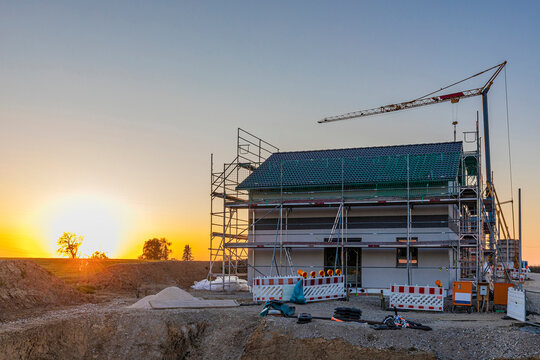 Modern house under construction with crane at sunset in Germany