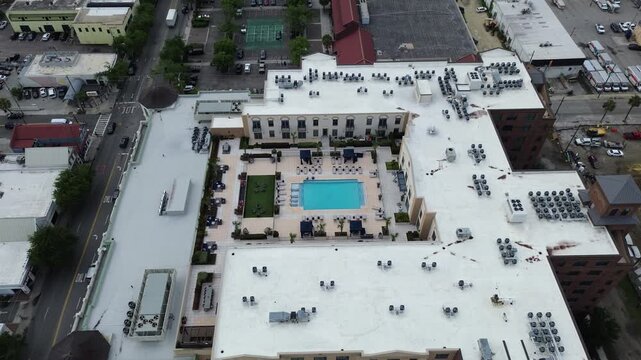 Rooftop systems layout near Meeting St Lee St captures residential buildings surrounding central courtyard in Charleston Upper Peninsula. White mechanical units, pool edges form patterns, SC