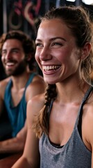 Fototapeta premium Young athletic couple laughing together during a fitness class at the gym