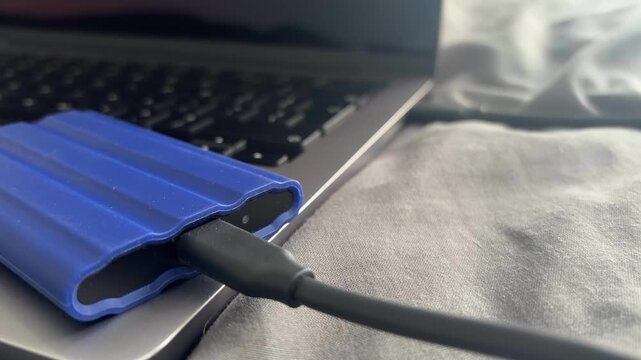 External SSD hard drive plugged into laptop data transfer files