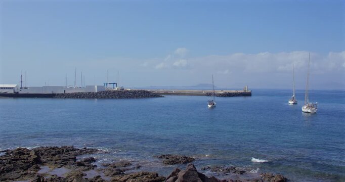 Extra wide shot of Two sailboats moored up outside Deportivo Rubic&oacute;n marina at Playa Blanca