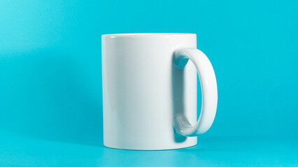 White ceramic mug stands against vibrant blue background. Simple design highlights clean lines and smooth texture. Perfect for branding, advertising, or product display © anton