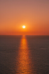 Fototapeta premium Bright sun setting over the calm Mediterranean sea horizon in Menorca coast