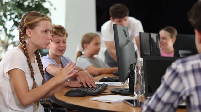Computer science lesson in a school computer class - a girl and a boy solve problems on the computer together. High quality 4k footage
