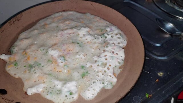 Closeup view of making dosa on hot pan showing cooking process and texture