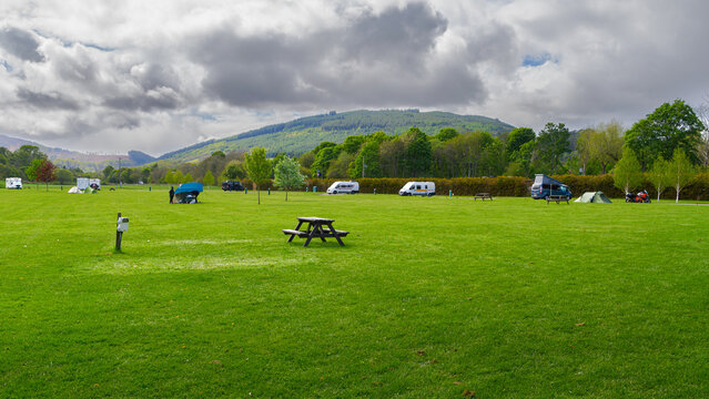 Camping verdoyant au bord du Loch Ness sous ciel nuageux