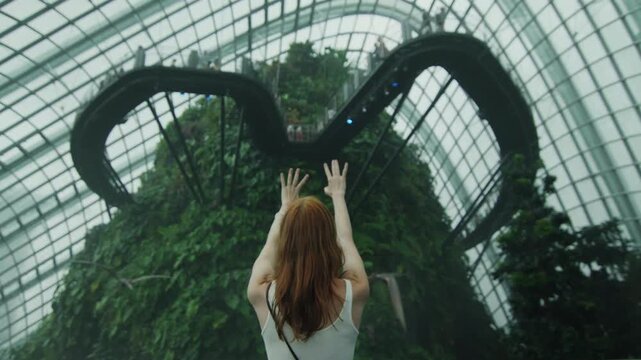 Woman with arms raised visiting cloud forest at gardens by the bay