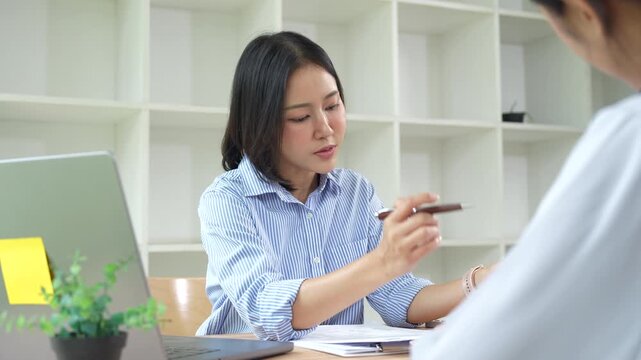 HR manager interviewing a job candidate across a desk, discussing qualifications and experience during a recruitment meeting in a modern office environment.