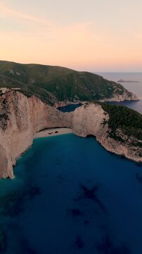 Immerse yourself in the stunning views of Navagio Beach, also known as Shipwreck Beach, in Zakynthos, Greece. The azure waters and majestic cliffs create a perfect vacation backdrop at sunset.