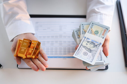 Businessman buying or selling gold, investing against inflation and currency depreciation.