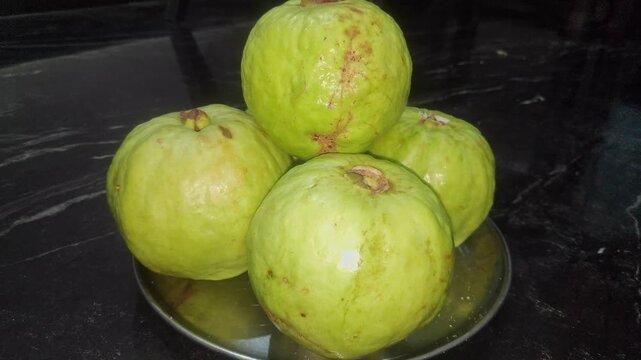 Closeup view of fresh guava fruits showing green skin and natural texture details