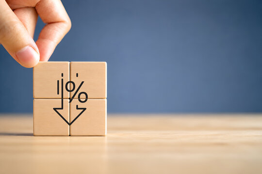 Financial decline and percentage decrease concept. Wooden blocks with downward arrow with a percentage sign, representing financial decline, economic downturn, decreasing interest rates, deflation.