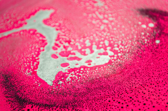 Bright colors mix together on a surface during an artistic process in a studio