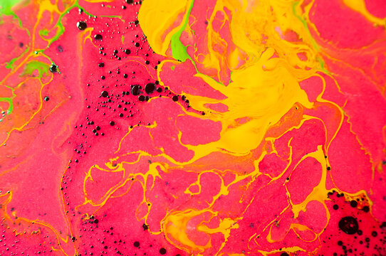 Bright colors mix in liquid art creation on canvas during a craft workshop