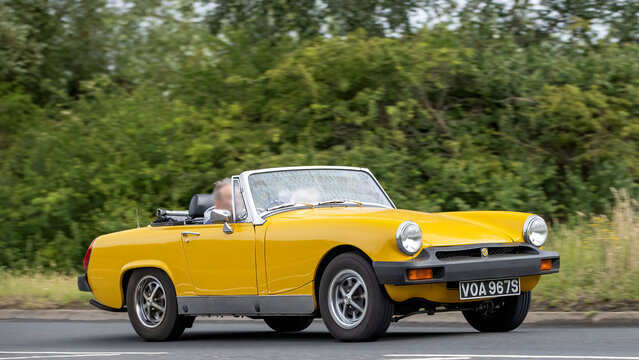 Stony Stratford,Bucks,UK - June 7th 2026: 1978 yellow MG Midget classic British sports car driving on a British road