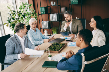 Fototapeta premium Professional team collaborating on business strategies during formal office meeting with diverse colleagues