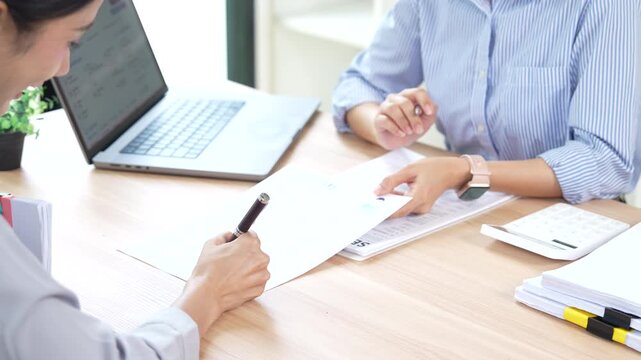 HR manager interviewing a job candidate across a desk, discussing qualifications and experience during a recruitment meeting in a modern office environment.