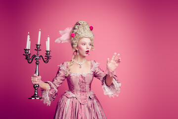 Fototapeta premium Photo of surprised lady medieval princess wonder castle with candle stick hold hands wear dress corset isolated pink color background