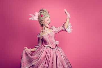 Fototapeta premium Photo of attractive carefree lady dressed baroque costume waving arm hi copy space isolated pink color background