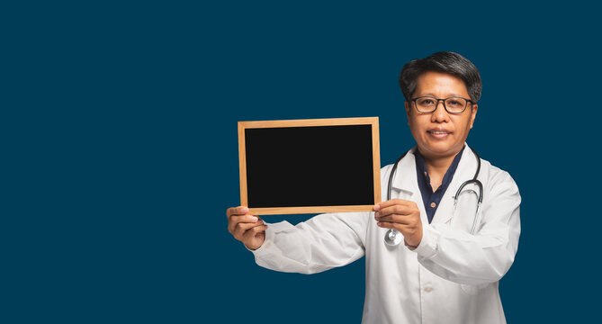 Female Doctor Holding Blank Chalkboard on Teal Background