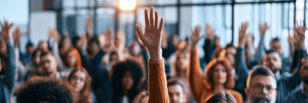Raised hand in corporate meeting with audience answering a question