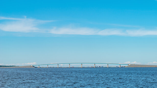 Modern concrete sea bridge structure near Hailuoto island in Oulu, Finland. Minimalist landscape with a distant bridge over the blue sea under a clear sky with copy space.