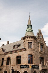 Obraz premium Historic stone building with a tall spire against a blue sky background