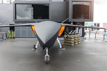 Front view advanced unmanned aircraft uav missile carrier outdoors wet pavement cloudy sky....