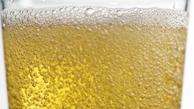 A close-up view of golden beer with effervescent bubbles and a frothy head, showcasing refreshment and celebration