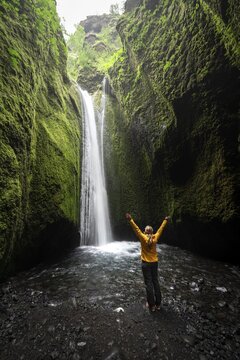 Hiker by a waterfall, river in Nauth&uacute;sagil Gorge, South Iceland, Iceland