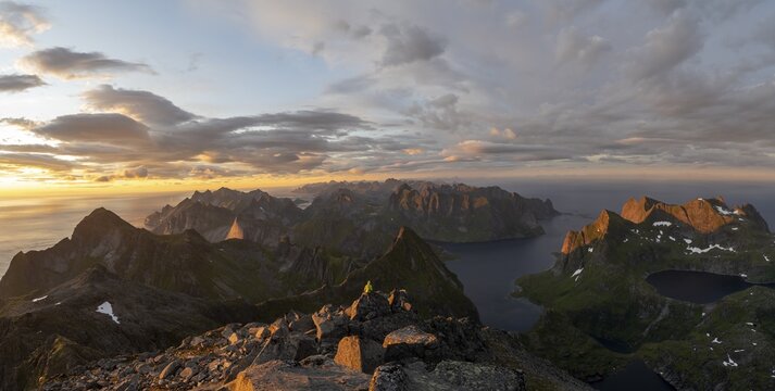 View over mountain peaks and sea, dramatic sunset, mountaineers at Hermannsdalstinden, with lakes Litlforsvatnet and Tennesvatnet and fjord Forsfjorden, Moskenes&ouml;y, Lofoten, Nordland, Norway