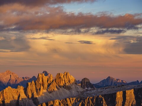 Alpine glow, rugged Dolomite peaks at sunset, colored clouds above, Dolomites, Alps, Belluno province, Veneto region, Veneto, Italy