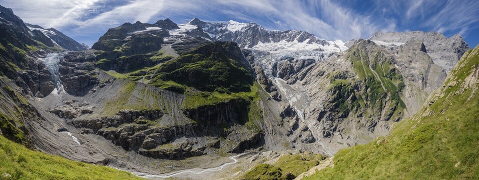Hiker (right) in the mountains on hiking trail to Grindelwald, left Lower Ice Sea Glacier Grindelwald-Fieschergletscher and summit of Walcherhorn, Bernese Oberland, Switzerland