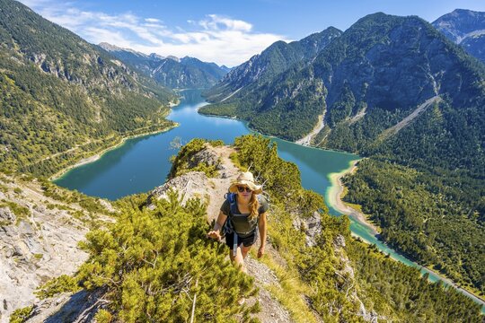 Hiker walking at Plansee, mountains with lake, Ammergau Alps, district Reutte, Tyrol, Austria
