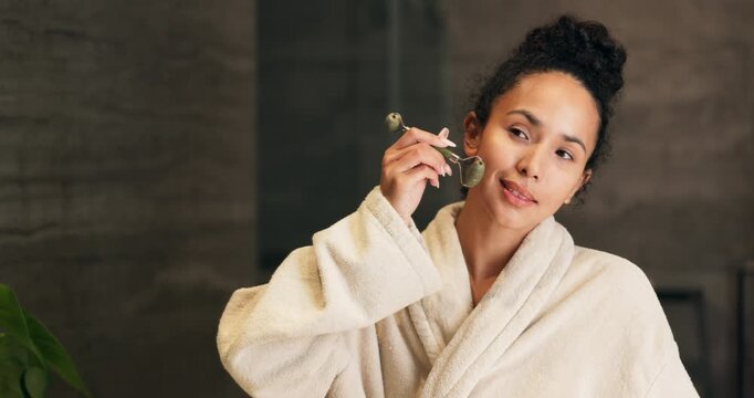 Woman, skincare and jade roller in bathroom with mirror, lymphatic drainage and calm morning routine. Person, getting ready and product in home with facial massage, reflection and blood circulation.