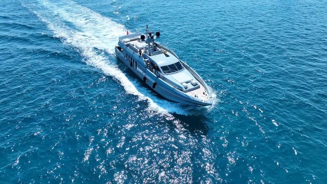 Aerial drone cinematic video of luxury yacht with wooden deck cruising in deep blue Mediterranean Sea